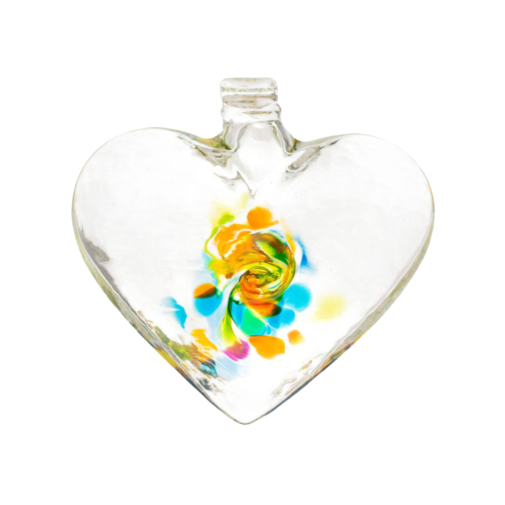 Clear glass heart with blue, orange, yellow, pink and opaque white glass swirled in the centre on a transparent background.