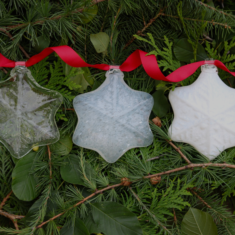 Clear, Milky and White snowflakes with a red ribbon on a bed of greens